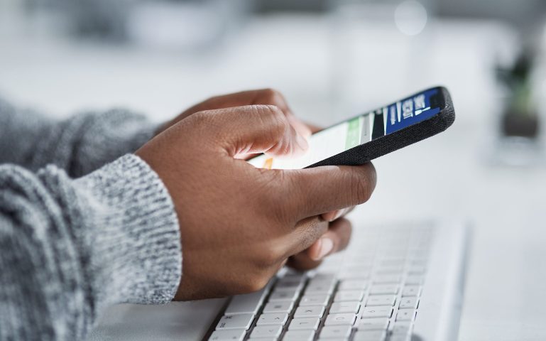 Hands, mobile phone and typing for communication with application, ux and connection in office. Business person, technology and website for scroll, network and social media as web designer in agency.